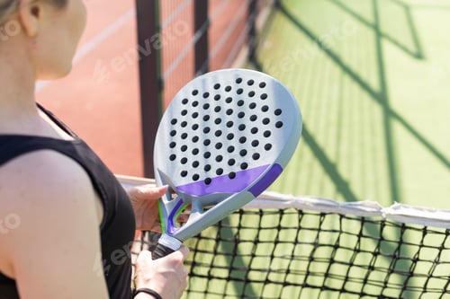Preview: hands of a woman paddle player is holding balls and the racket at the background at the beginning of