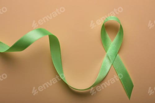 Preview: World Mental Health Day. Green ribbon on color background, top view