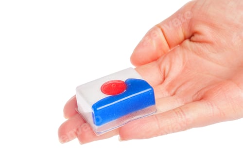Preview: Holding a small dishwashing soap tablet in hand for cleaning dishes