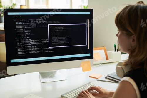 Preview: Young Caucasian Woman Developing Neural Network Code on Desktop Computer