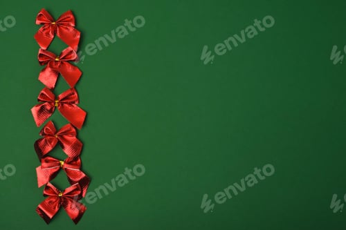 Preview: Red bright festive bows on a green background