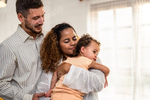 Visualização: Casal afro-americano segurando uma menina na sala de estar em casa.