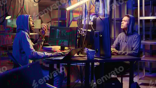 Preview: Two Young Men Working With Computers at Night