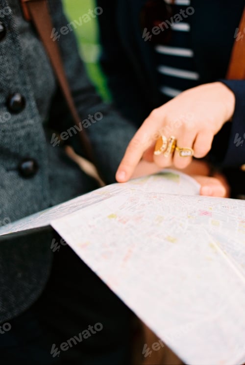 Preview: Two people using a map or guide book to find their way around a city.