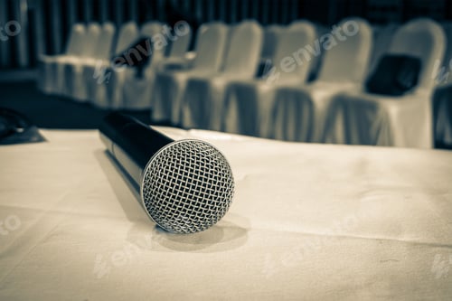 Preview: Microphone over the Abstract blurred photo of conference hall or seminar room background