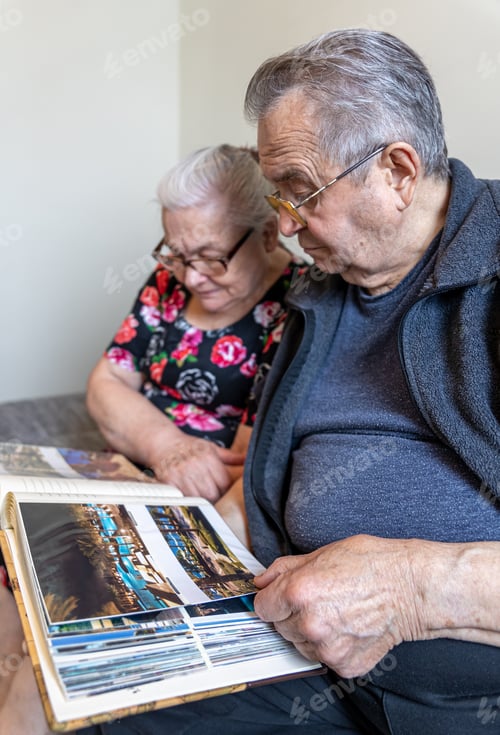 Preview: An elderly man and woman are looking at family photo albums.