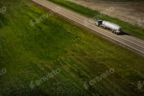 Preview: High angle shot of a big tanker truck rolling down on a highway surrounded by green fields