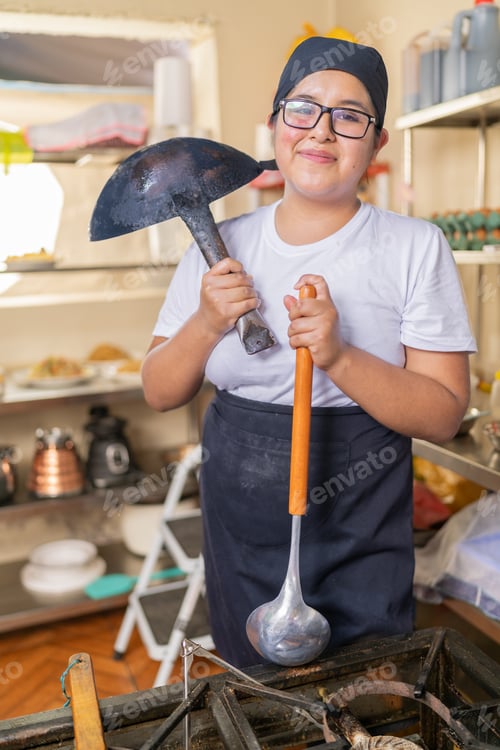 Preview: Chef holding kitchen utensils and smiling at camera