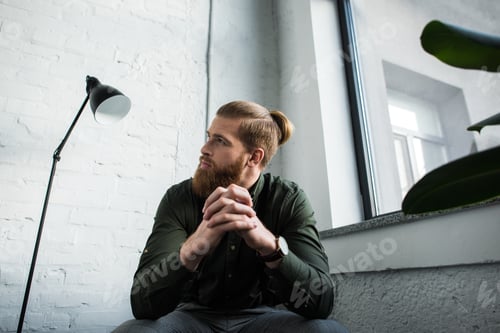 Preview: bottom view of businessman sitting and looking up