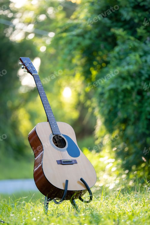 Preview: Acoustic guitar outdoors on greenery background. Concept of calm music