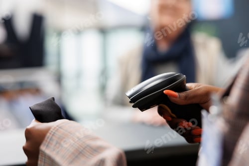 Preview: African american worker scanning fashionable shirt