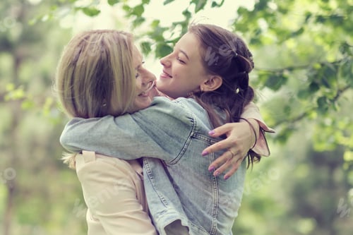 Preview: happy mother with her daughter hugging a teenager in the summer.
