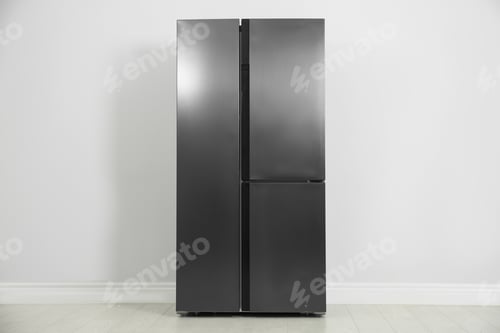 Preview: Modern refrigerator near light grey wall. Home appliance