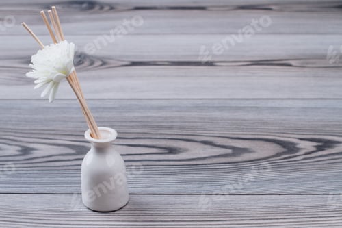 Preview: The white vase with artificial flowers and wooden sticks.