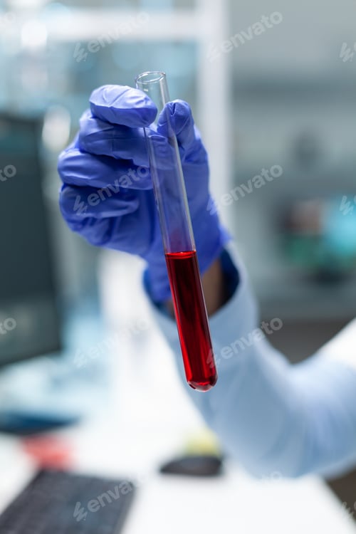 Preview: Closeup of biologist chemist holding medical test tube with blood developing virus treatment