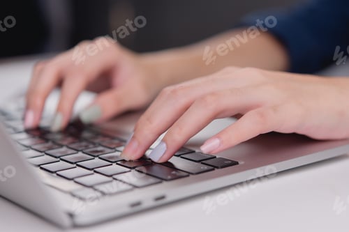 Preview: close-up shot of a person typing on a laptop keyboard, showing a modern workspace