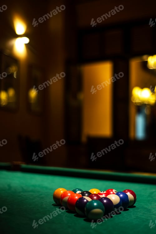 Preview: billiards balls on pool table in cozy dark bar interior