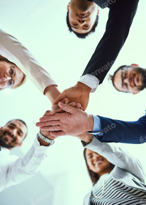 Preview: Low angle shot of a diverse group of businesspeople joining their hands together in unity
