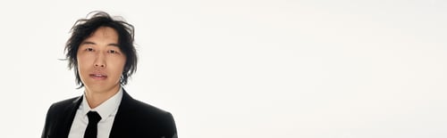 Preview: Stylish young asian man exuding confidence against a minimalist backdrop