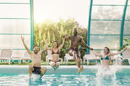 Preview: Multiethnic young friends having fun at pool while jumping in the water - Travel summer concept