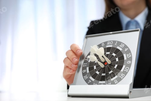 Preview: Woman with darts at table. Business trainer concept