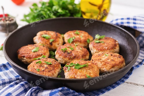 Preview: Juicy delicious meat cutlets in pan on a wooden table.