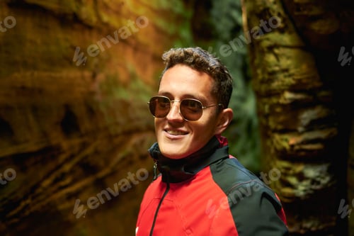 Preview: Shallow focus shot of handsome young Hispanic boy with sunglasses and coat posing in nature