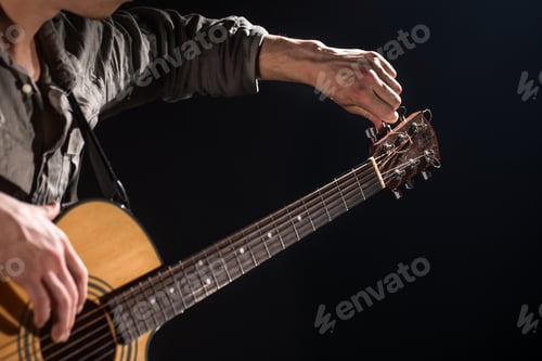 Preview: Guitarist, music. A young man plays an acoustic guitar on a black isolated background