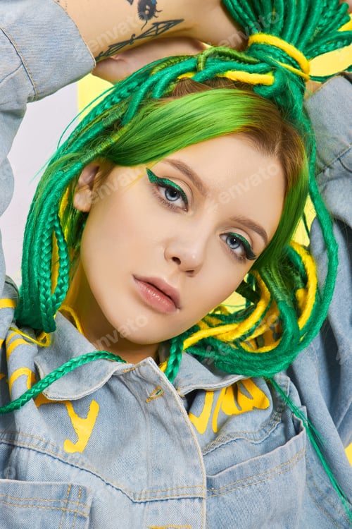 Preview: Portrait of woman with creatively colored hair in green and yellow color. Colorful bright dreadlocks