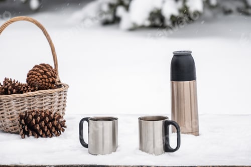 Preview: Thermos and metal cups on snow outdoors