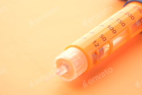 Preview: Insulin pens on orange background, close up