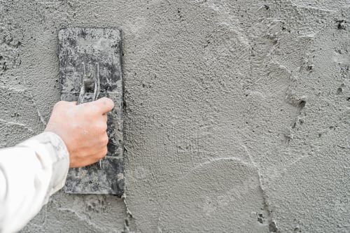 Preview: Hand plasterer plastering cement wall background, hand worker brush rough concrete floor for smooth