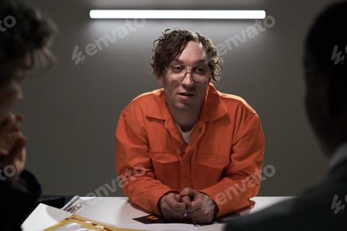 Preview: Portrait of Man in Orange Jumpsuit Engaging in Conversation