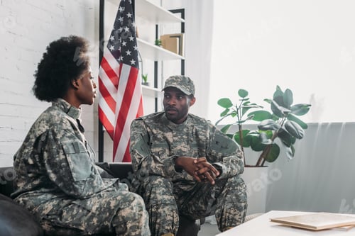 Preview: Woman and man in army uniform talking on sofa at home