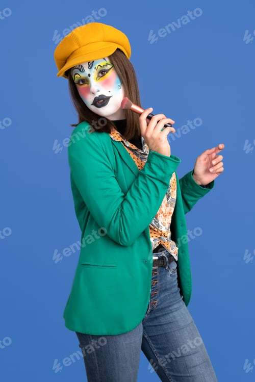 Preview: Woman made up for carnival on blue background with makeup brush