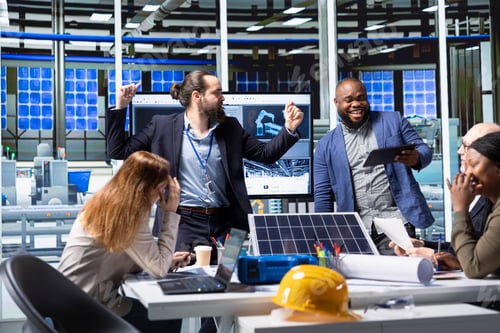 Preview: Happy businessmen in solar panel plant celebrating increased sales