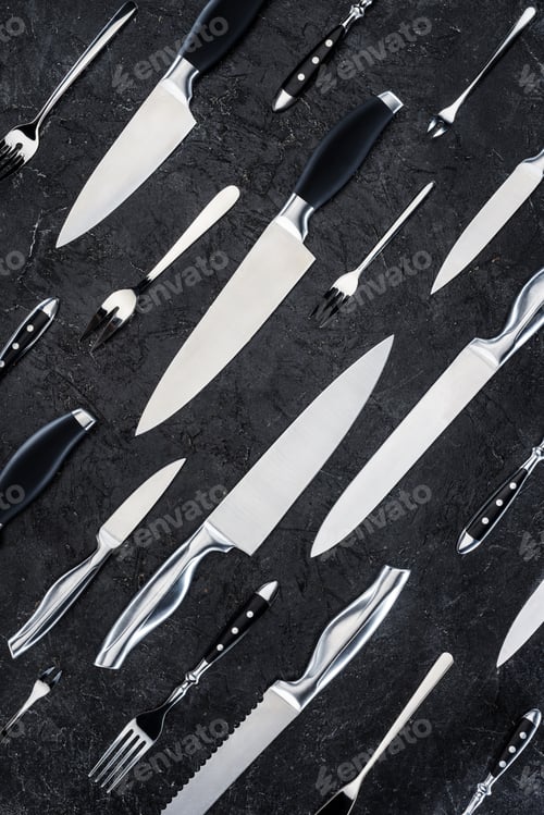 Preview: top view of various forks and knives on black surface