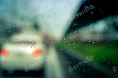 Preview: Rain drops on windshield. Car driving on asphalt road on rainy day. Windshield window of car