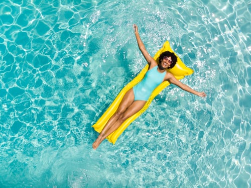 Preview: Young biracial woman enjoys a relaxing day at the pool, with copy space