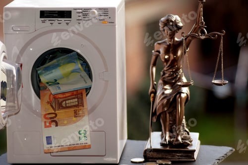 Preview: Washing machine toy filled with paper money and a Themis statue next to it