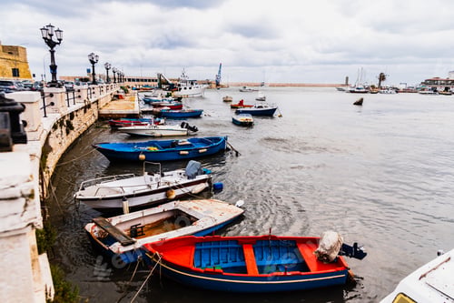 Preview: Bari, Italy - March 12, 2019: Old fishing boats moored to port dirty and in disuse.