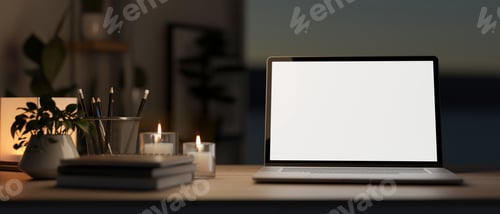 Preview: White screen laptop with books aside aroma candles and potted plants on wooden table in a dark room.