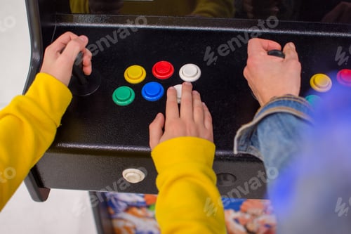 Preview: Detail on hands playing with joystick on old vintage arcade game in a dark room for playing video ga