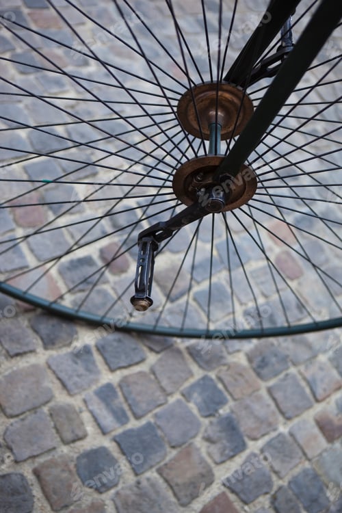 Preview: Vintage Bicycle Wheel on Cobblestone Street