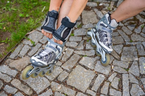 Preview: Close up view of feet in inline skates of roller skater woman. Rollerblading in park. Outdoor