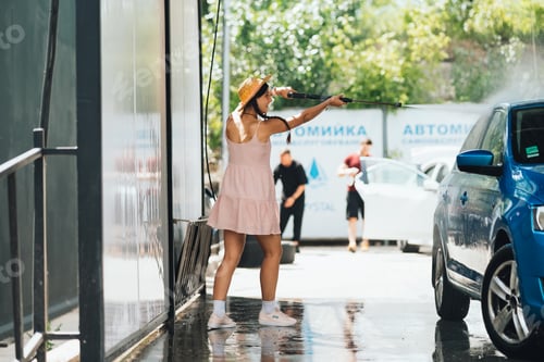 Preview: Brunette from a high-pressure hose washes the car