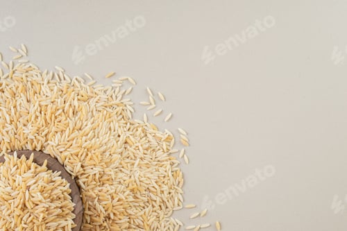 Vista previa: Yellow rice seeds in a cup on concrete background