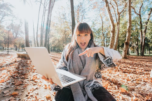 Vista previa: Chica trabajando en portátil en el parque de otoño. Concepto de trabajo independiente