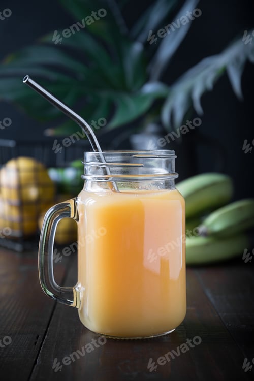 Preview: Fresh fruits smoothies or juice with orange, lemon, banana, lime on dark tropical background.