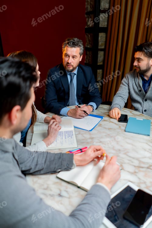Preview: office workers are sitting at the head of the director discussing a business plan